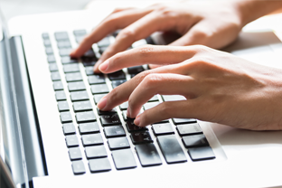 Bild: 2 Hände tippen Tastenkombinationen in ein Keyboard eines Laptops